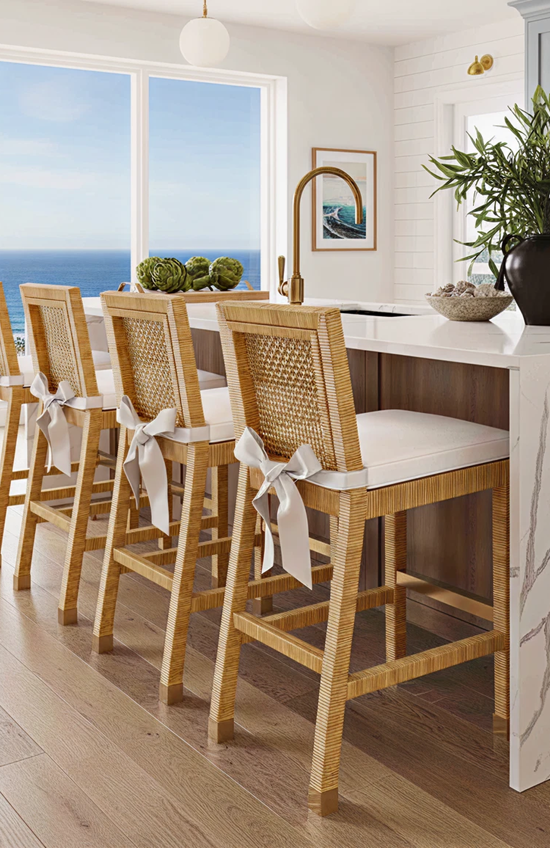 Wooden bar stools with white cushions in a kitchen with ocean view