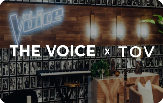 Promotional image for 'The Voice' with 'TOV' branding on a stage setup.