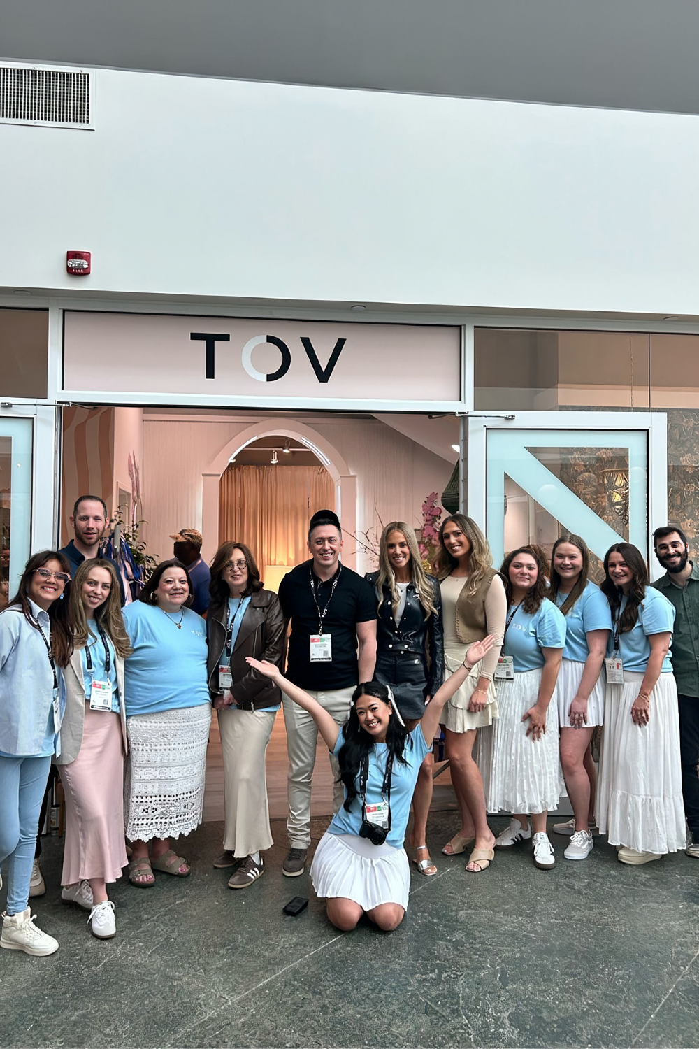 Group of people posing in front of a building with 'TOV' signage.