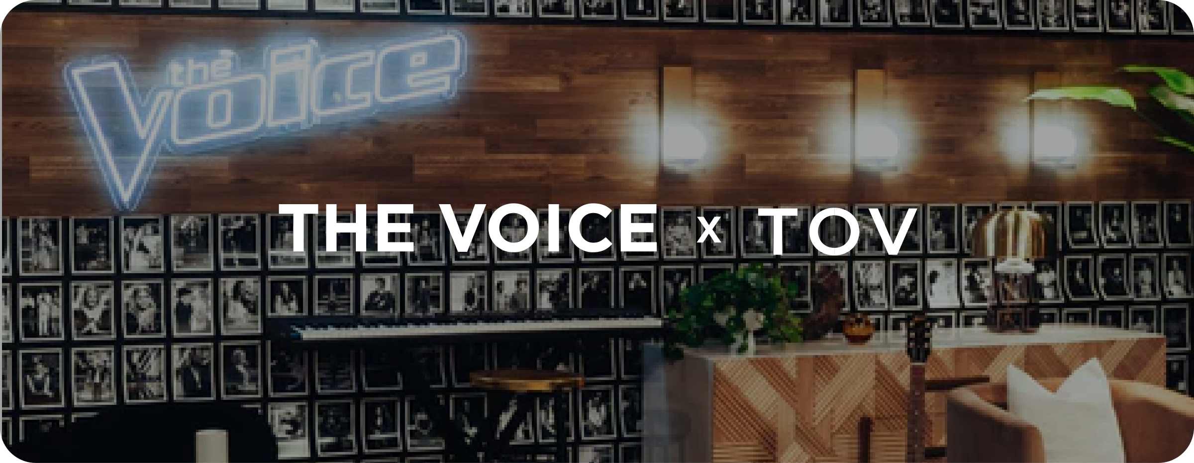 Promotional image for 'The Voice' featuring a branded wall with 'The Voice x TOV' text.